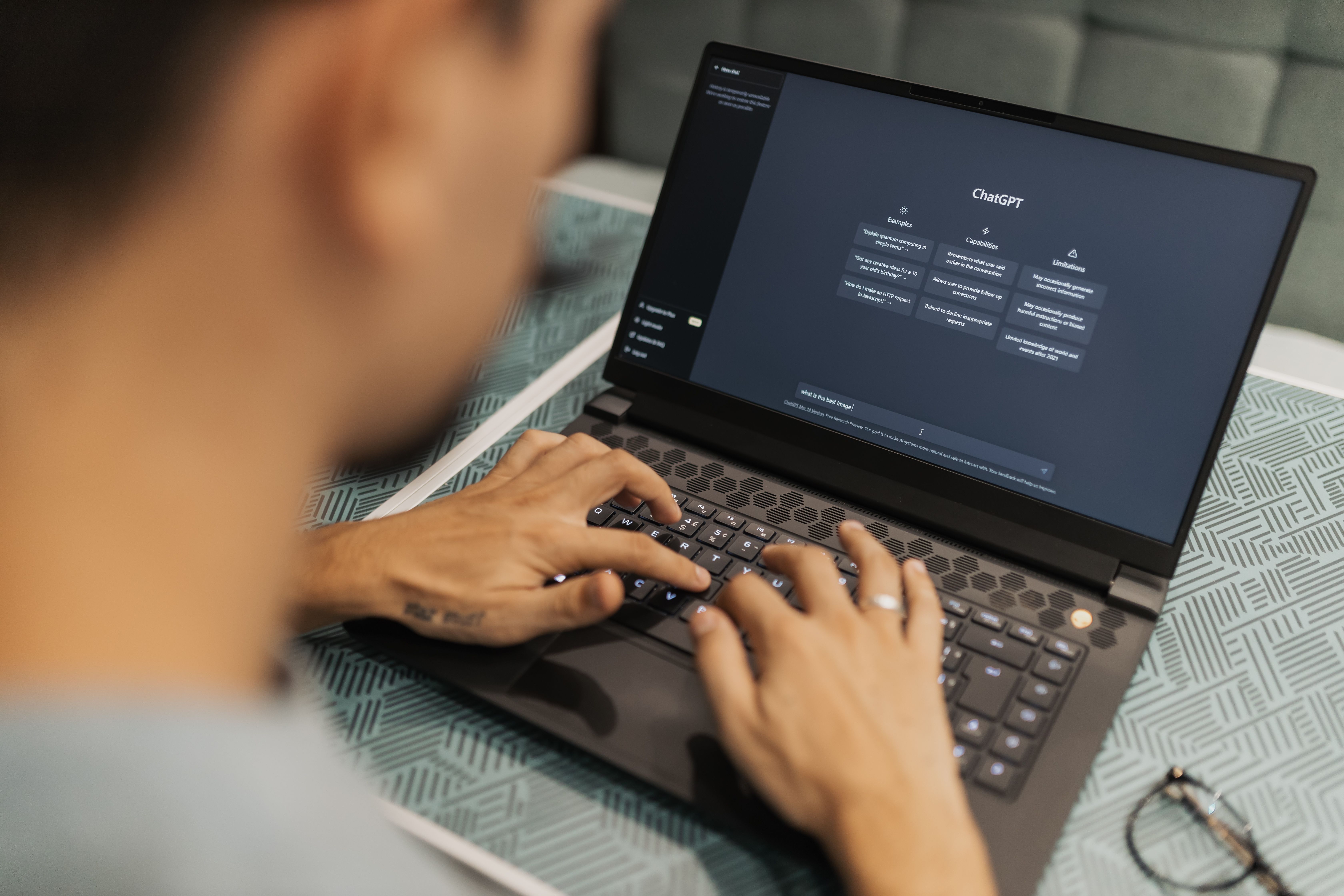 A person looking overwhelmed while working on a laptop